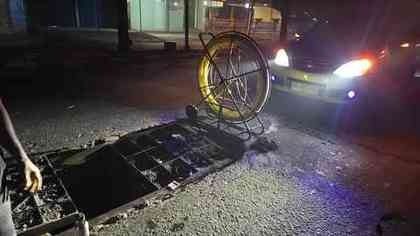 Haspel kabel optik di mulut manhole pada malam hari